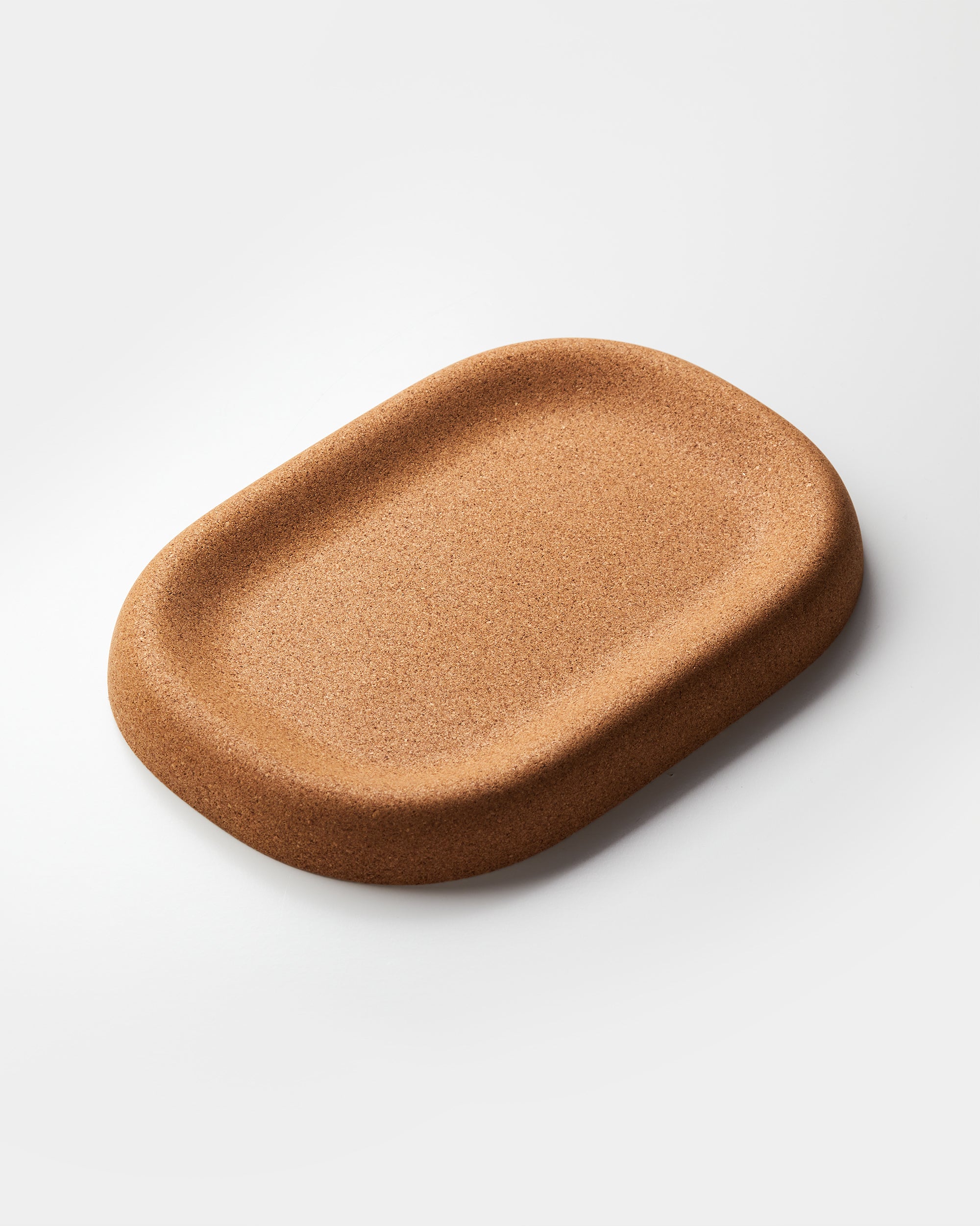 Craighill Little Cloud Tray, a tan cork catchall with rounded edges, photographed at an angle on a light background.