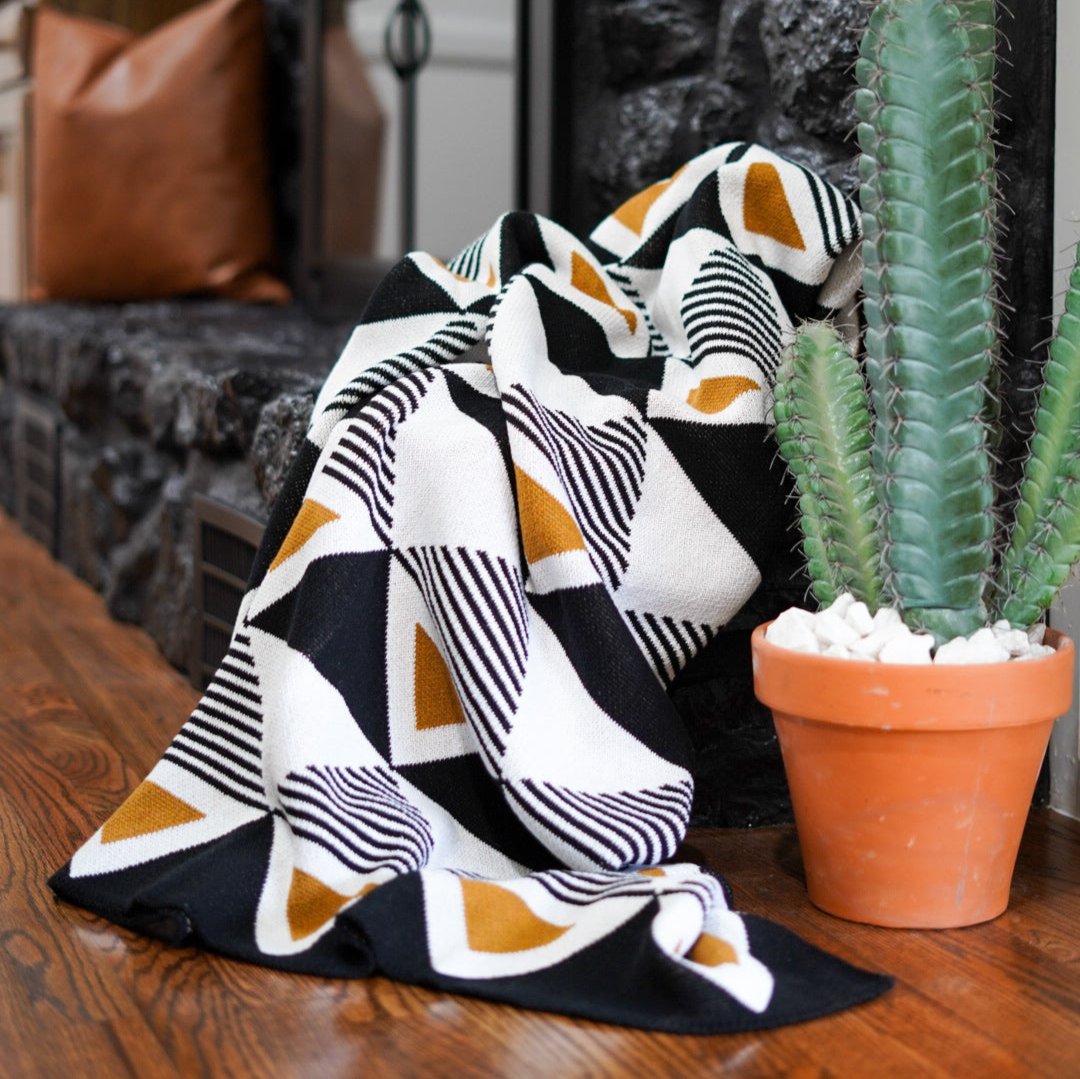 Seek & Swoon Envie Throw in mustard, black, and white, with geometric patterns and fringe.